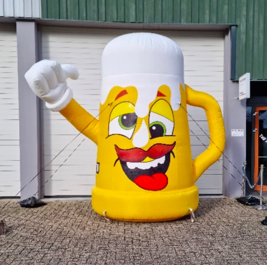 Opblaasbare gele bierpul van 3,5 meter met lachend gezicht en opgestoken duim, staand voor het pand van Opblaaswereld de Blok.