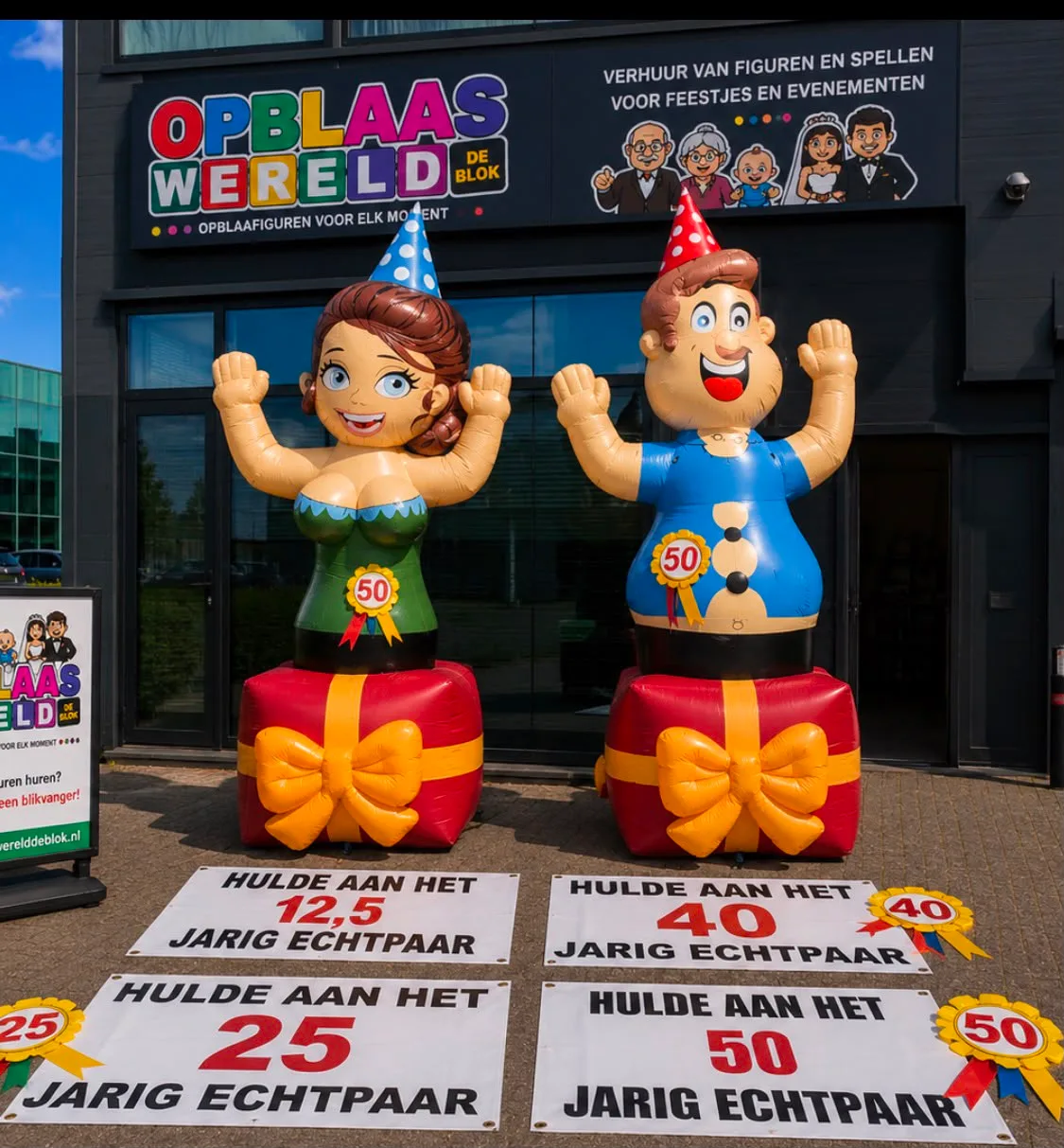 Twee opblaasfiguren van vier meter, een man en een vrouw met feesthoedjes, staand op rode cadeaus met gele strik, met spandoeken voor 12,5, 25, 40 en 50 jaar getrouwd.