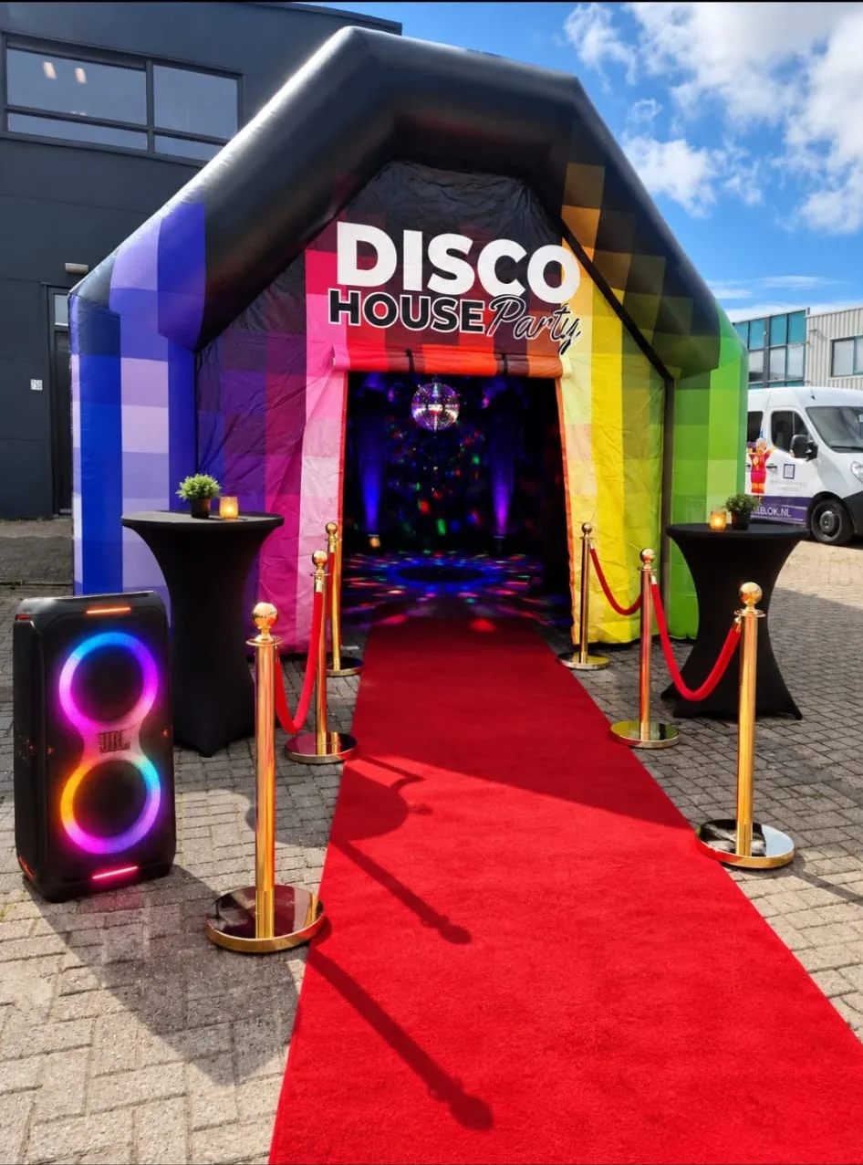 Opblaasbare feesttent met kleurrijk design en de tekst Disco House Party, met open ingang en toegangsluik.