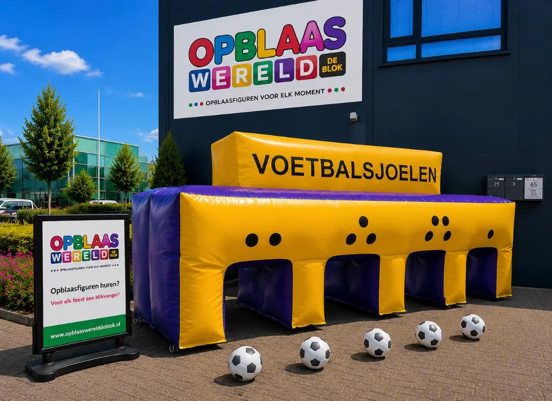 Groot geel en blauw opblaasbaar voetbalsjoelen spel met vier openingen en het woord VOETBALSJOELEN erop, met vijf voetballen ervoor, buiten opgesteld bij Opblaaswereld de Blok.