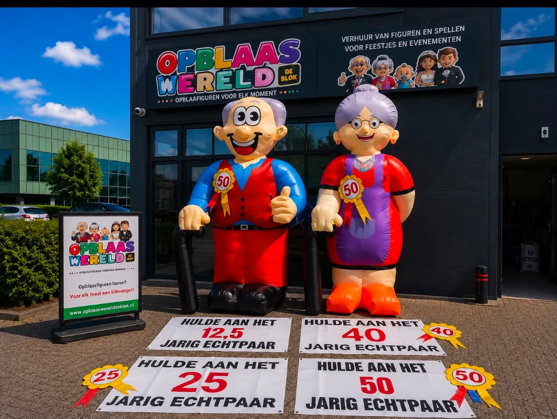 Twee opblaasfiguren van een ouder echtpaar met rozetten, opgesteld voor het pand van Opblaaswereld de Blok, met spandoeken voor jubilea van 12,5, 25, 40 en 50 jaar.