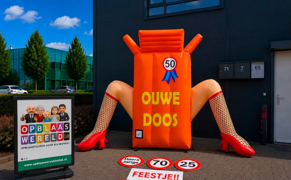 Opblaasbare oranje Sarah Oude Doos van 2,5 meter met tekst 'Ouwe Doos', rozet met 50, benen met netkousen en rode hakken, opgesteld voor een bedrijfspand.