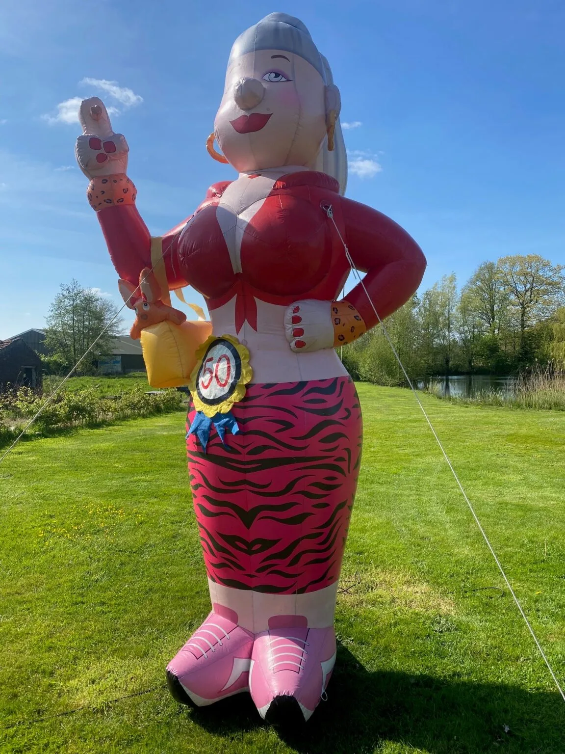 Opblaasfiguur van Sarah, 3,5 meter hoog, met ordinaire uitstraling en rozetten, voor een 50e verjaardag.
